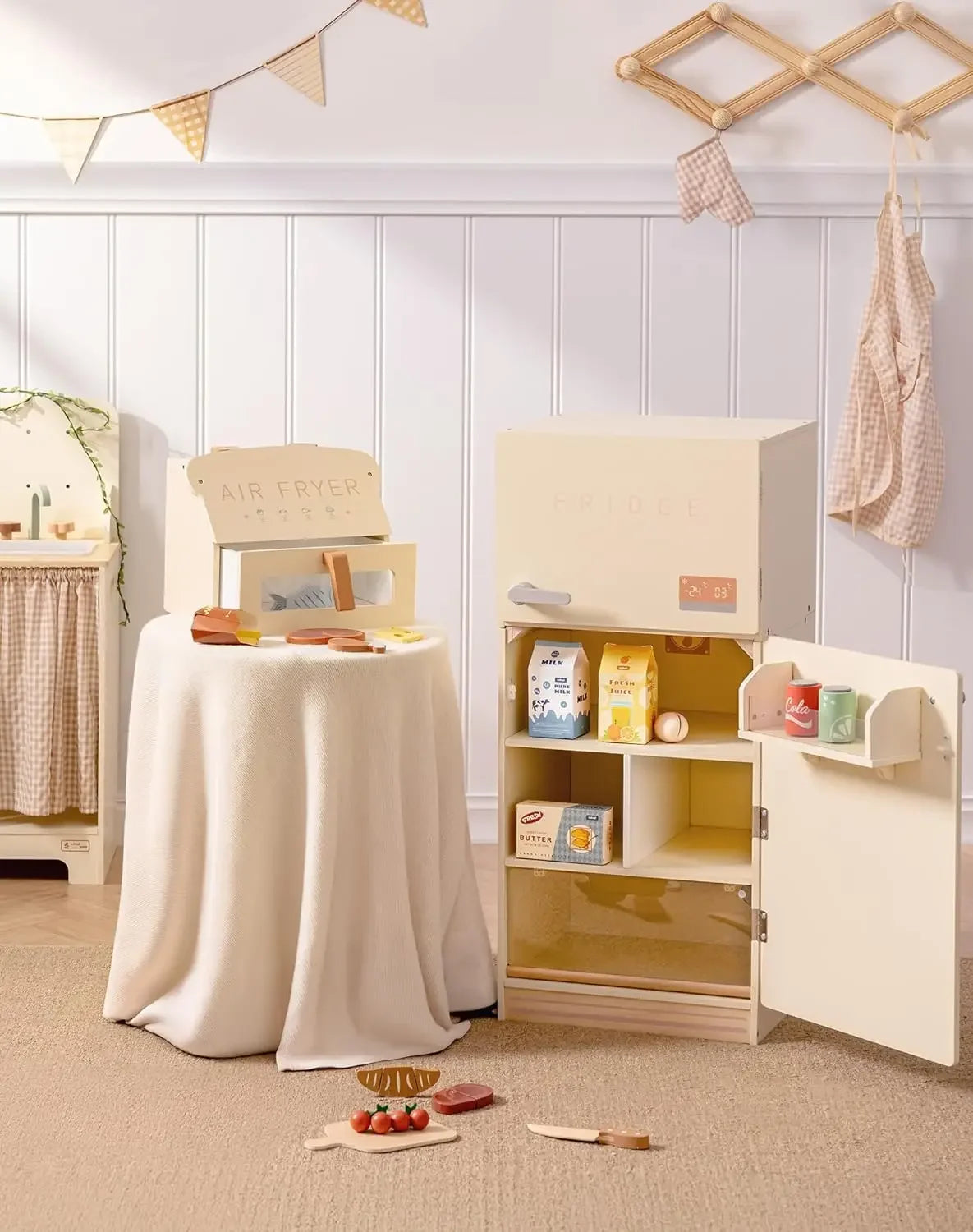 Children's play kitchen set with various accessories in a room setting.