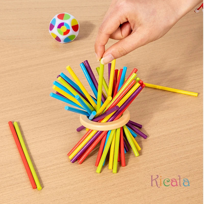 Colorful straws arranged in a circular pattern on a wooden surface with a hand interacting with them.