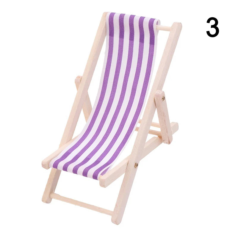 Miniature deck chair with purple and white striped fabric on a white background