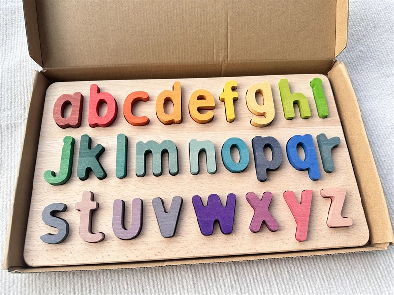 Colorful wooden alphabet letters set in a cardboard box on a light background
