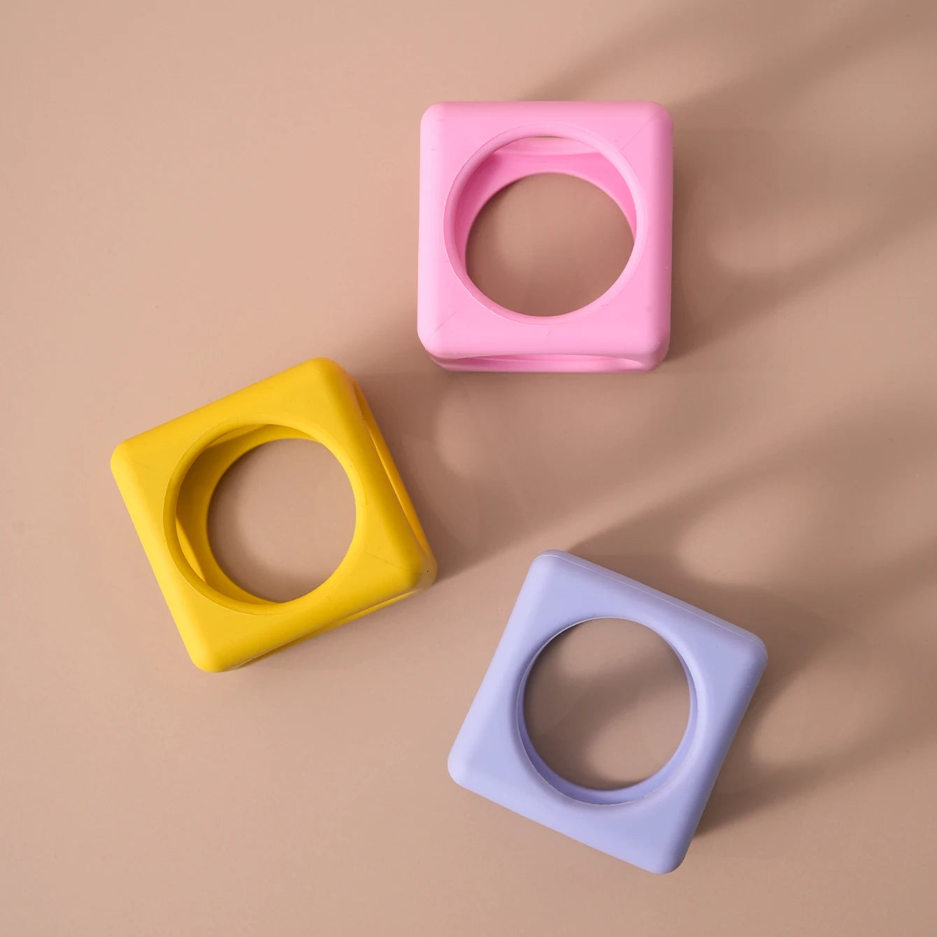 Three silicone cube teethers seen from above