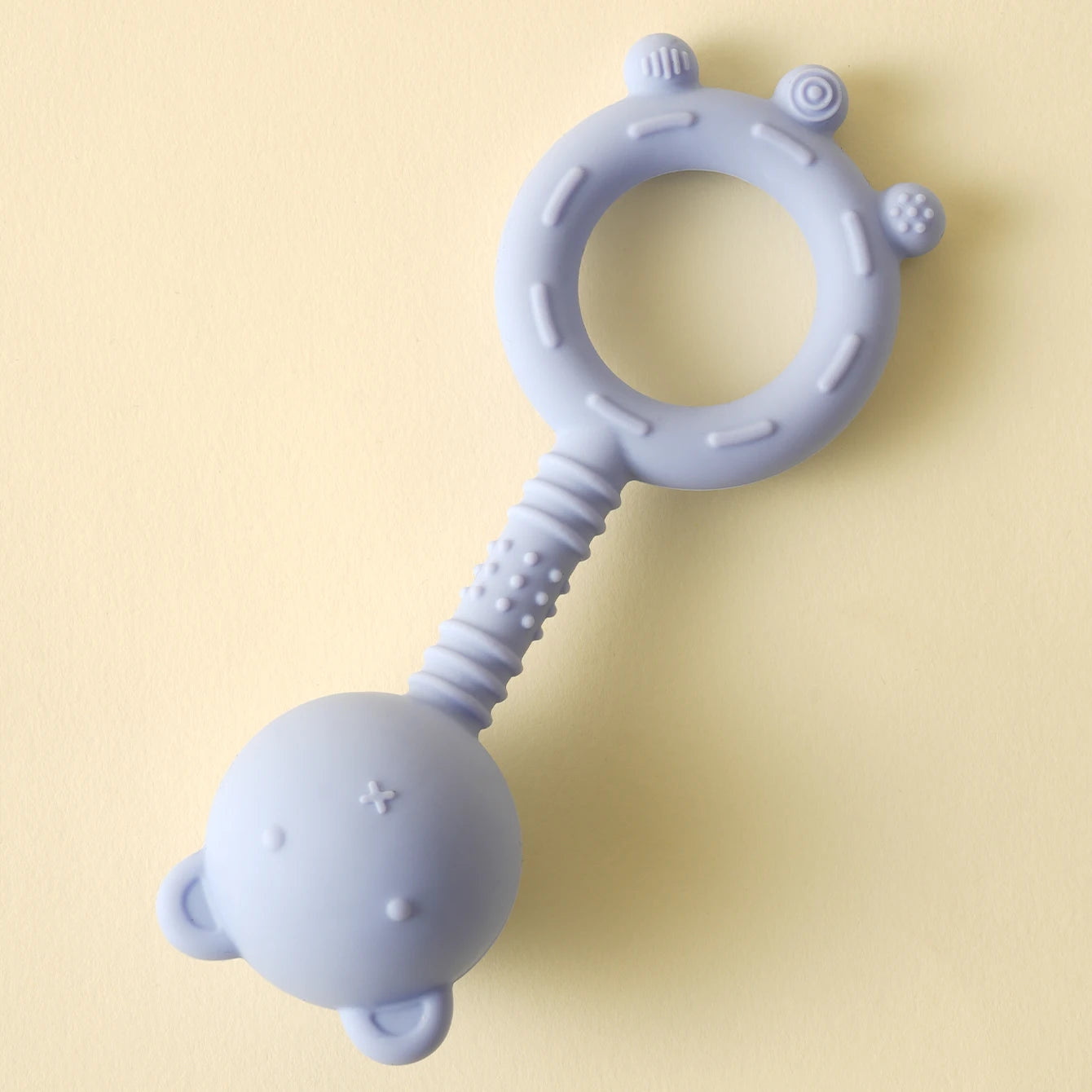 Silicone teething ring with a ball on a light yellow background