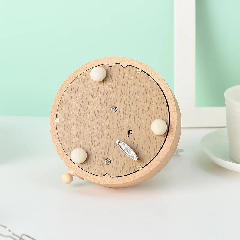 Wooden clock with white accents on a light surface against a light green background