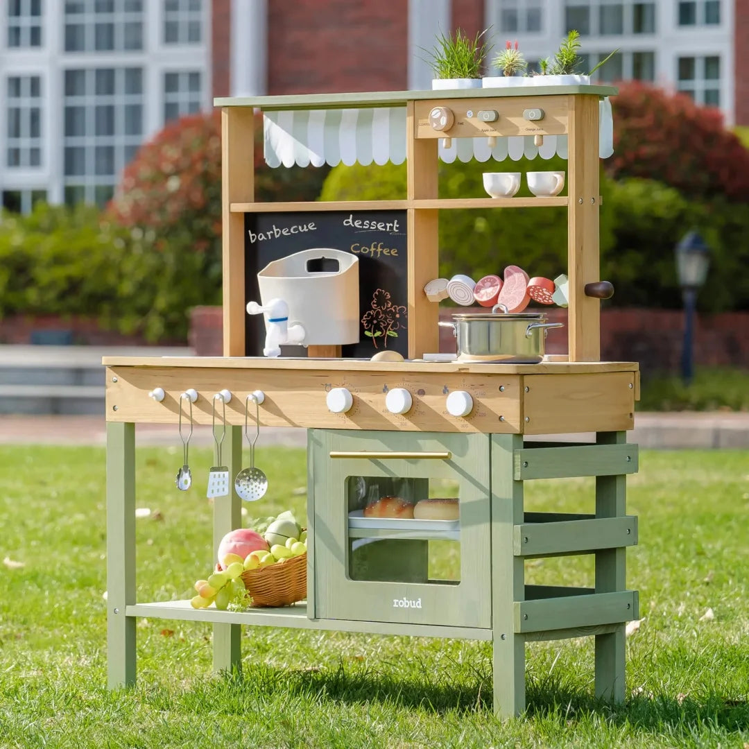 Children's play kitchen set outdoors with various accessories and a chalkboard.