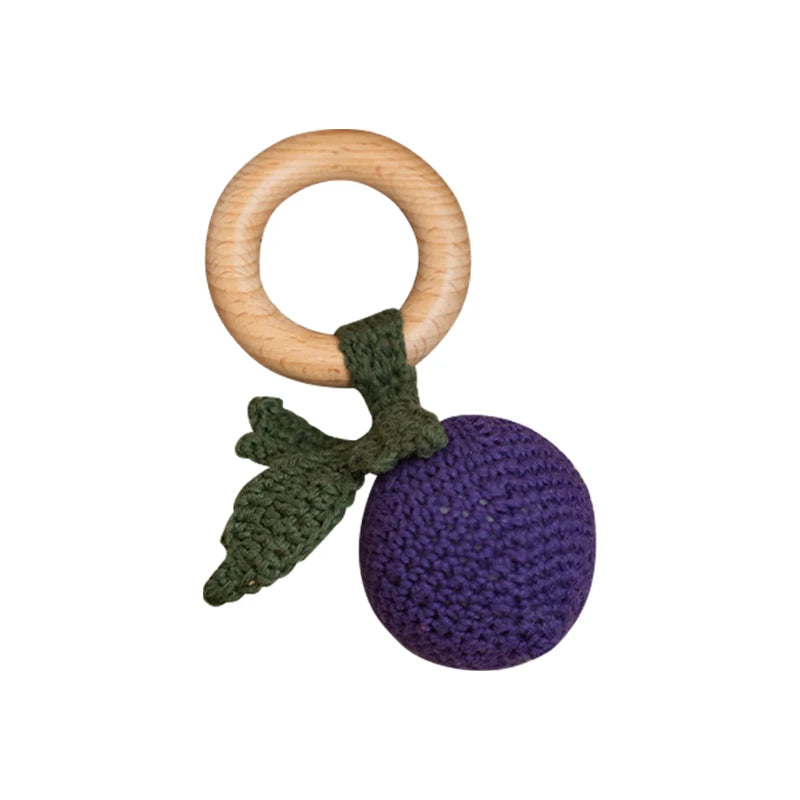 Wooden teething ring with purple and green accents on a white background