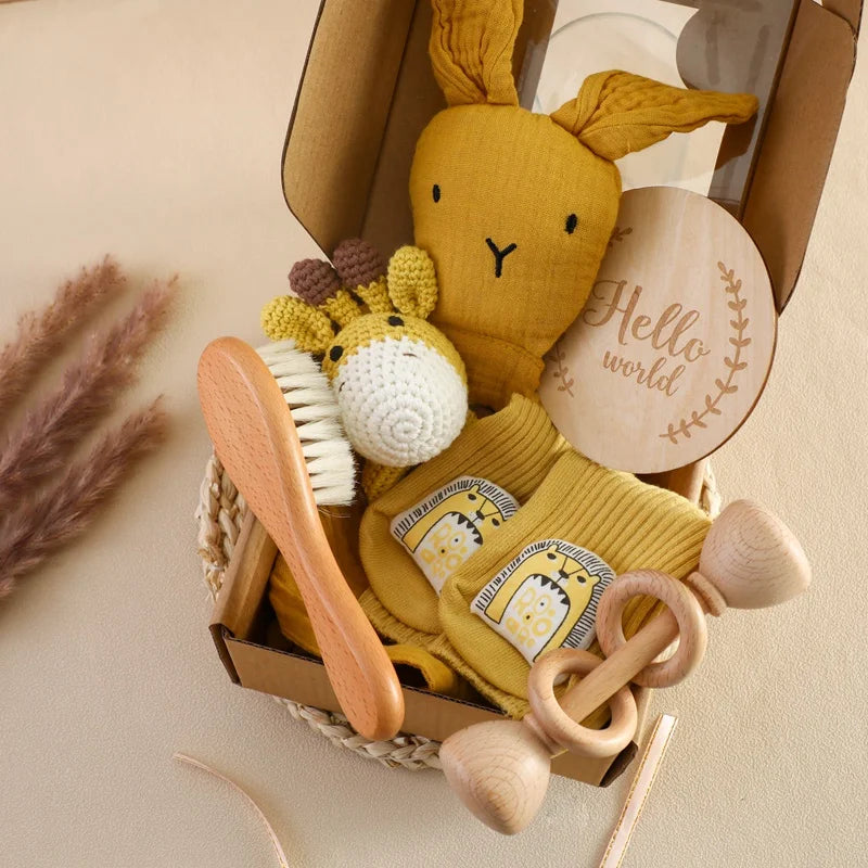 Baby care set with yellow plush toy, wooden brush, and other items in a box on a beige background.