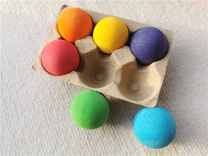 Colorful foam balls in an egg carton on a textured surface