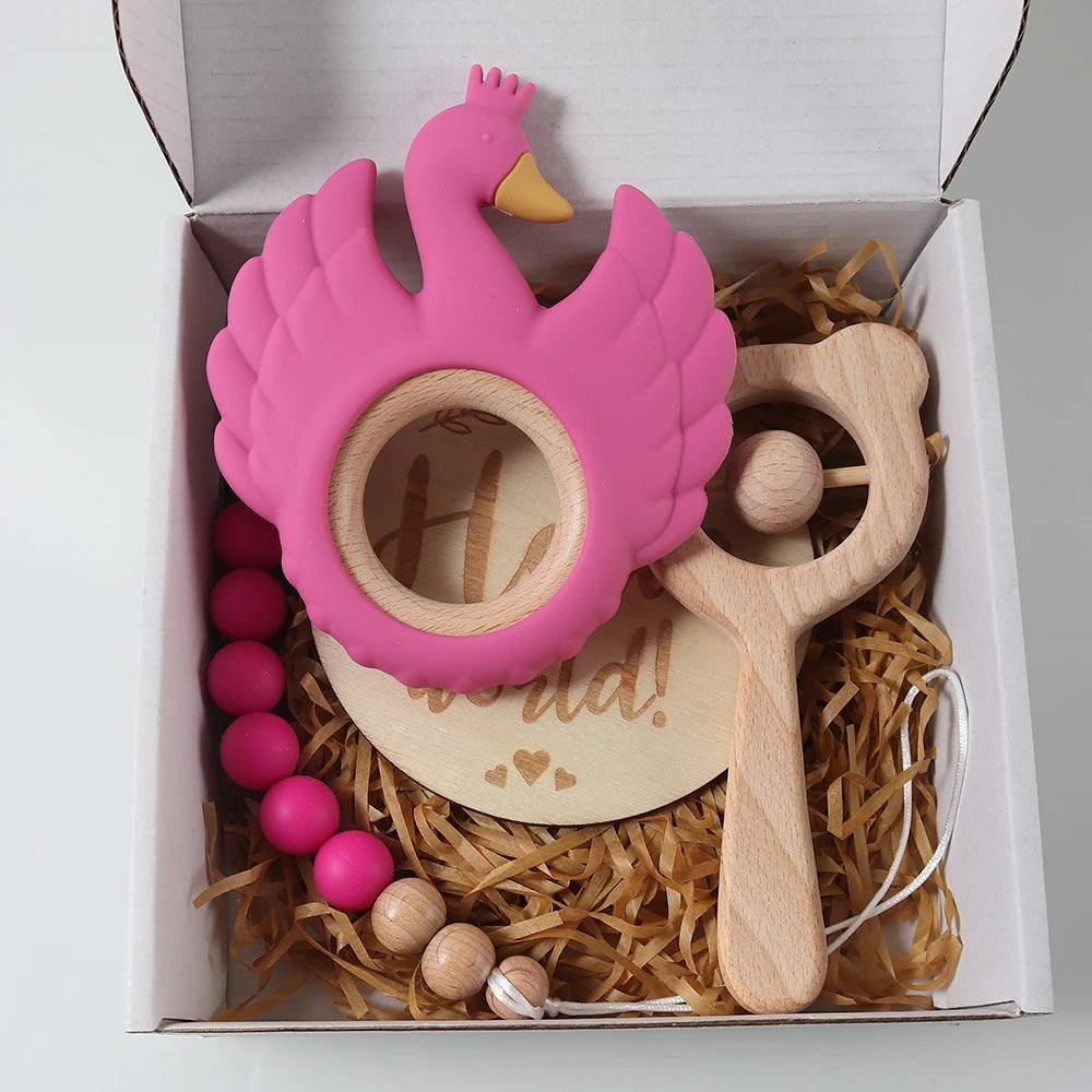 Pink flamingo-shaped teether with wooden rattle and beads in a gift box