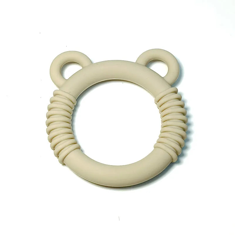 A beige silicone baby teether with a textured, ribbed design and two small loop handles resembling ears, shown on a plain white background.