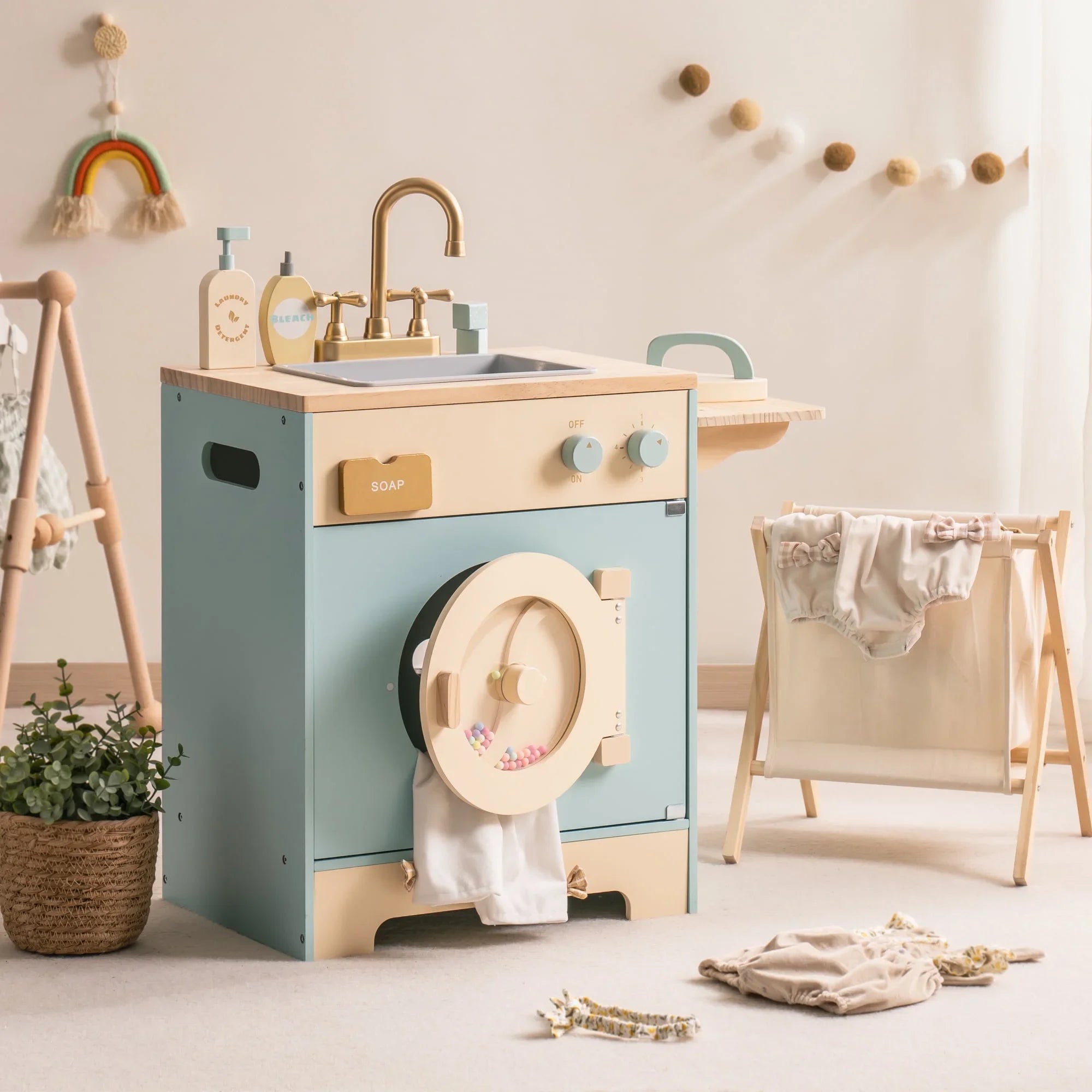 Children's play kitchen set with sink and washing machine in a room setting.