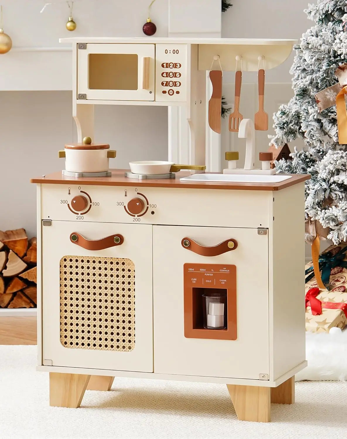 Wooden play kitchen set with toy appliances and utensils in a festive setting.