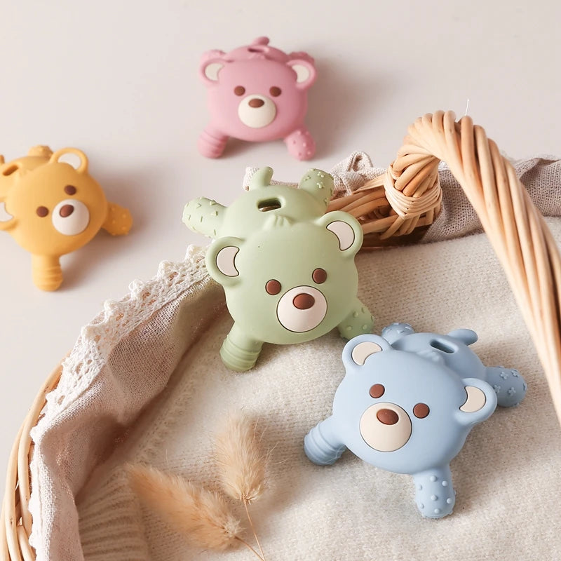 Four colorful bear-shaped toys on a soft surface with a woven basket.