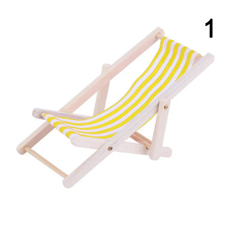 Miniature folding beach chair with yellow and white striped fabric on a white background
