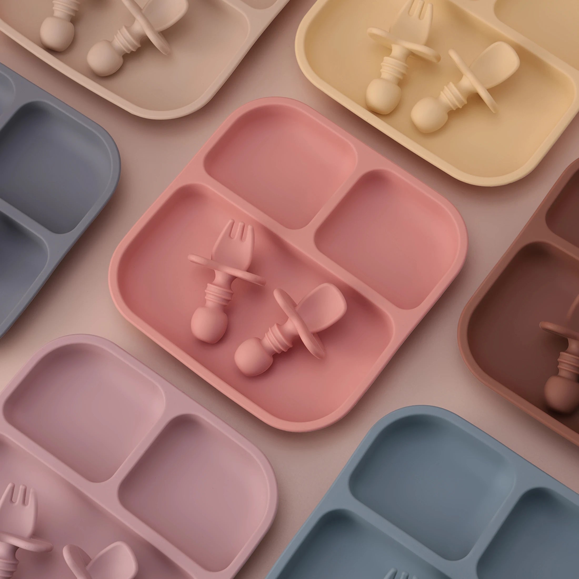 Colorful children's plates and utensils arranged on a flat surface