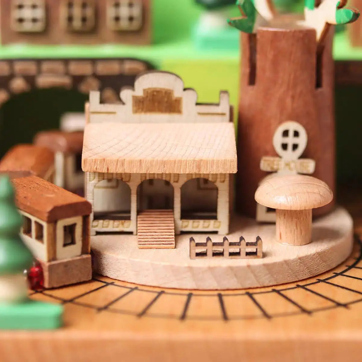 Wooden toy village set with buildings and trees on a wooden base