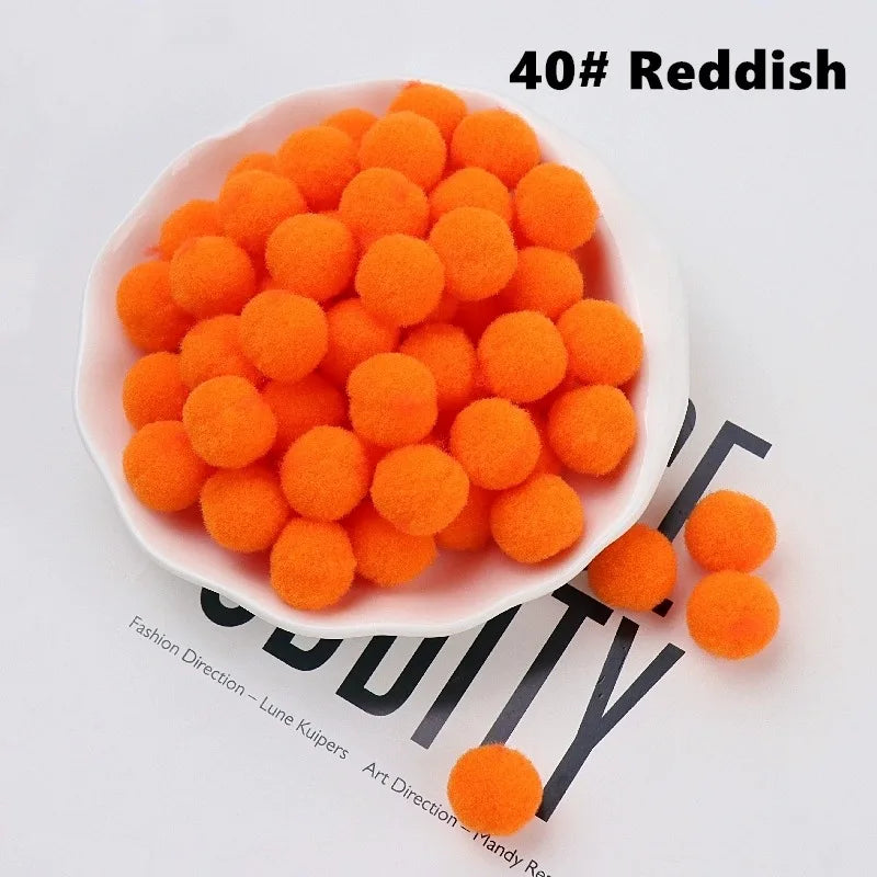 White bowl filled with orange pom-poms on a magazine background