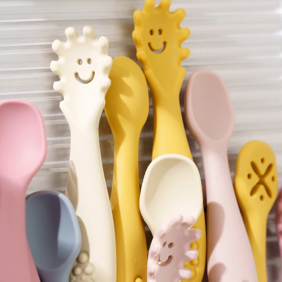 Close-up of smiling sun, classic and dipper silicone spoons