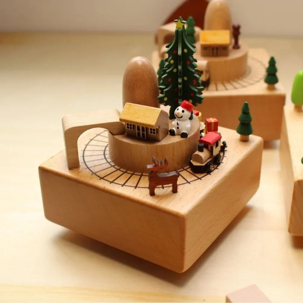 Wooden toy set with a train, houses, and trees on a light surface.