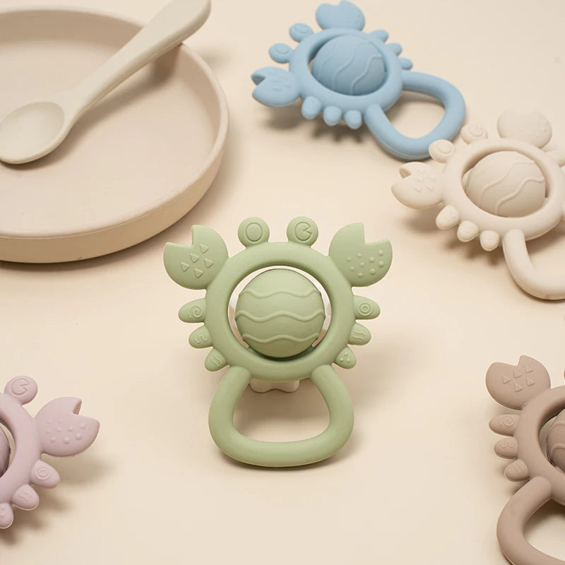 Collection of colorful baby teething toys on a light beige surface
