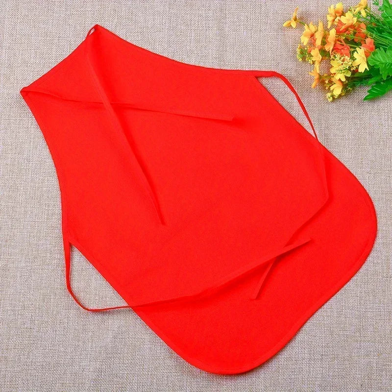 Red apron on a textured surface with flowers in the corner