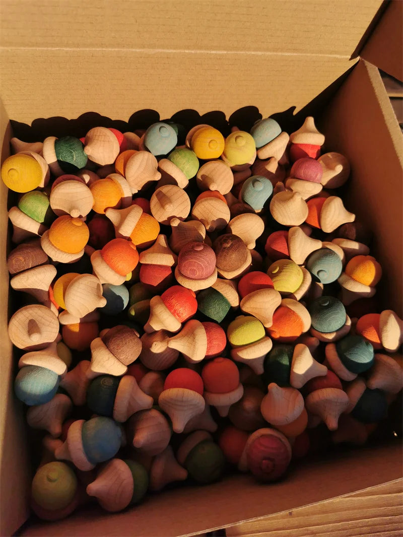 Box filled with colorful wooden toys shaped like acorns.