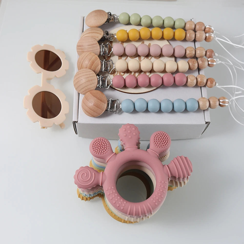 Baby teething ring and colorful beaded toys on a white background
