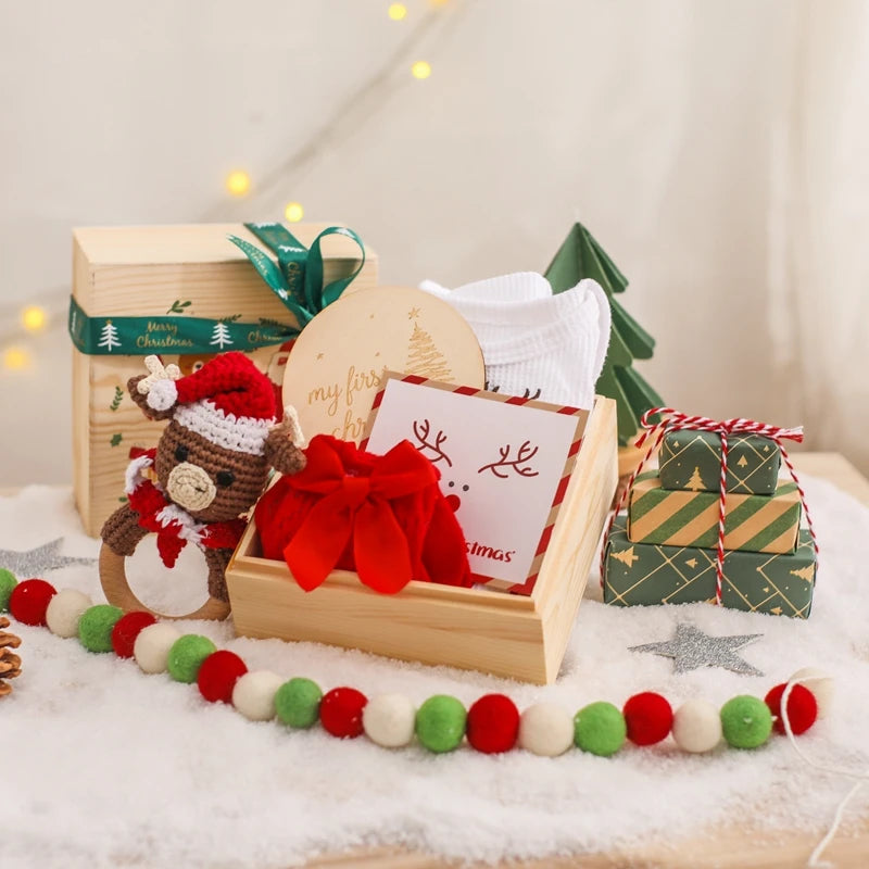 Baby Christmas Gift Set featuring gift boxes, a knitted stuffed animal, and decorative elements. Perfect for celebrating your baby's first Christmas with joy and style.