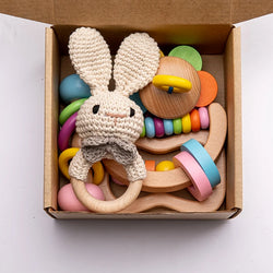 Wooden Baby Rattle Gift Set featuring handcrafted musical rattles and bell toys, designed to stimulate sensory development in infants. Perfect for new parents seeking Montessori-inspired toys.