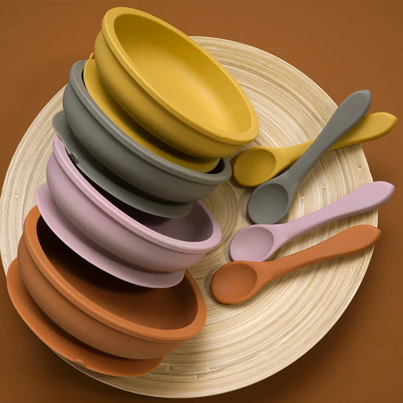 Stack of wide silicone suction bowls with spoons