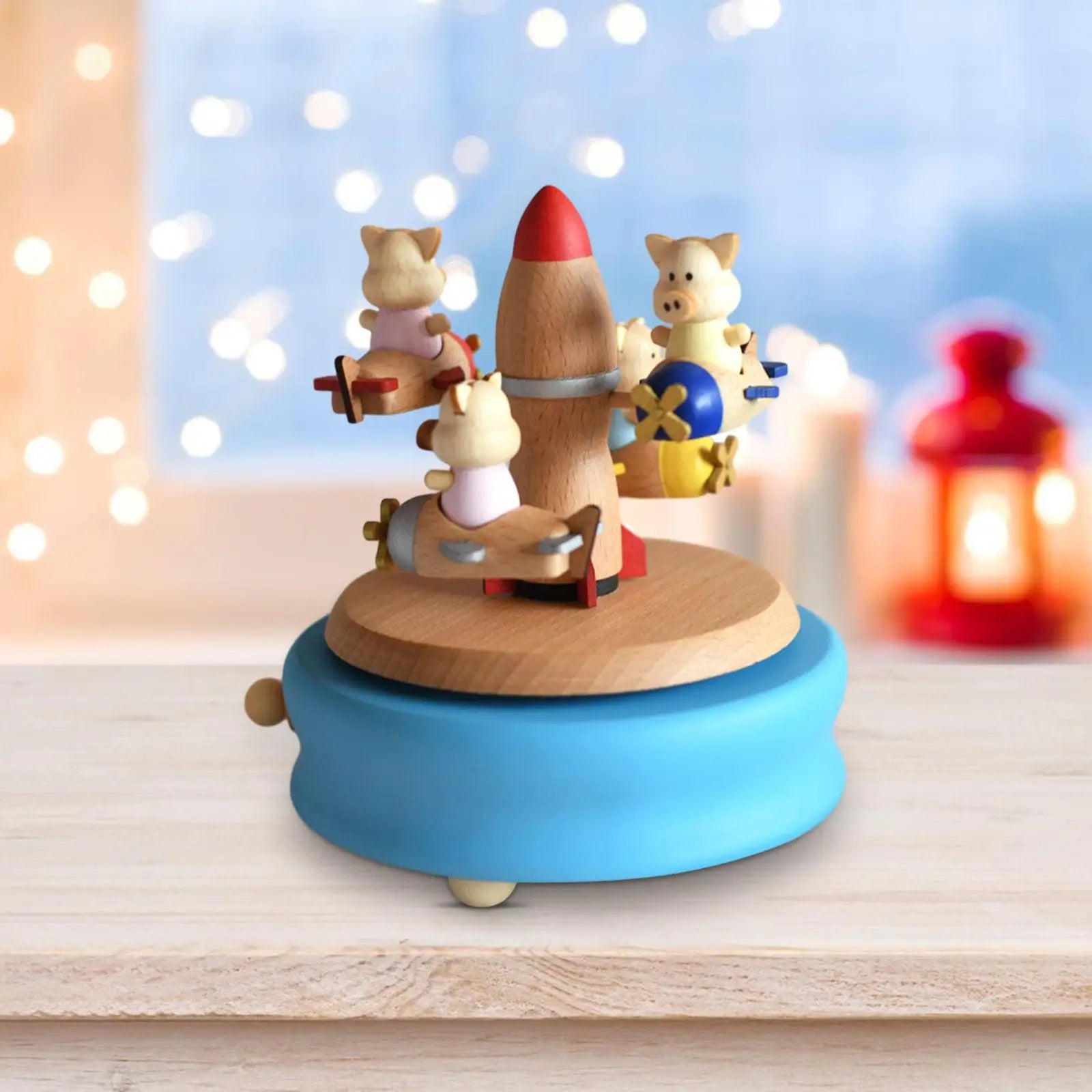 Wooden toy with pigs and a rocket on a blue base against a blurred light background | Oliver & Company Montessori Toys