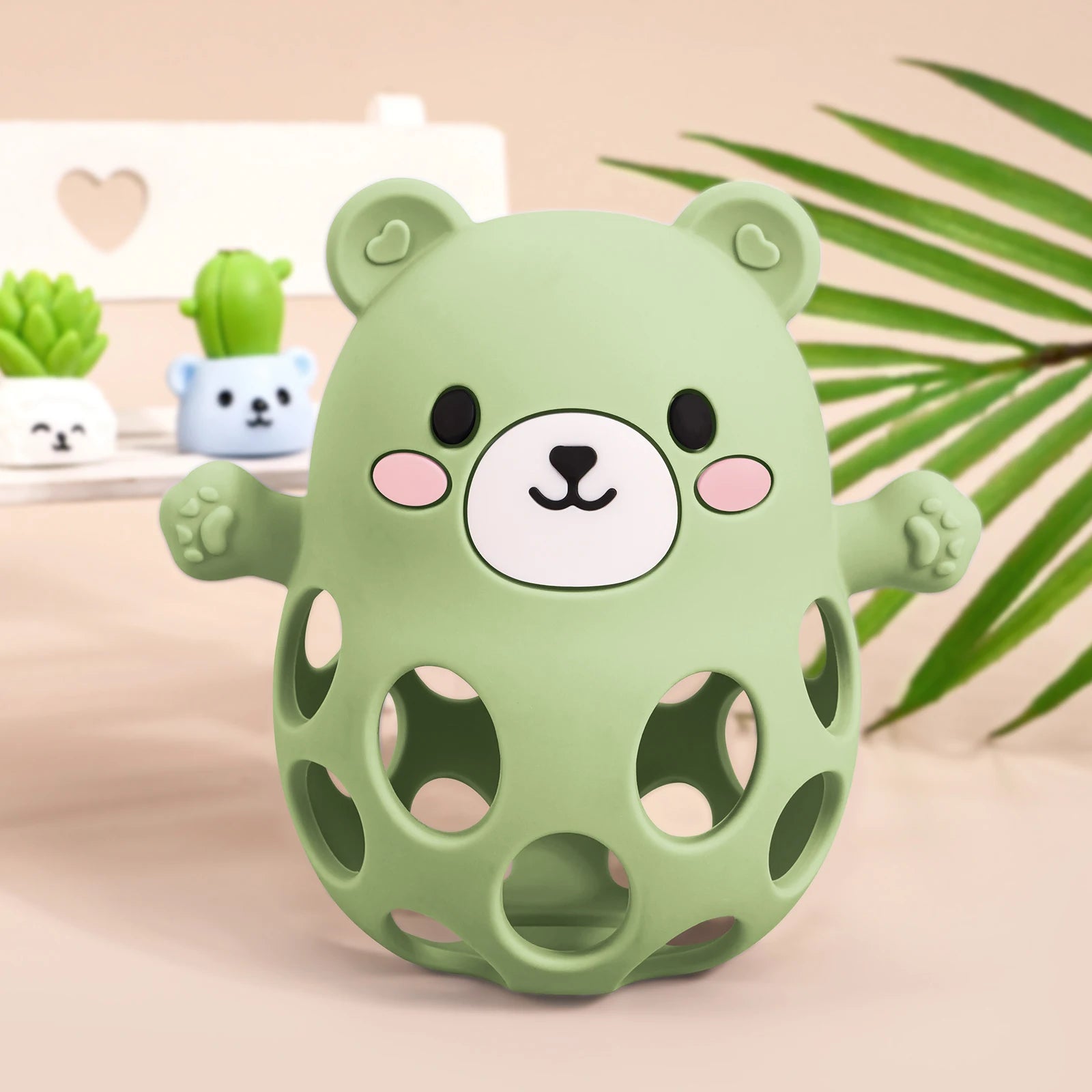 Green bear-shaped toy with a face on a beige background