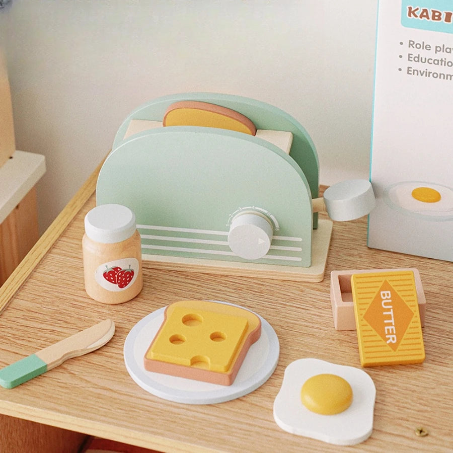 Toy toaster set with bread, butter, and egg on a wooden surface