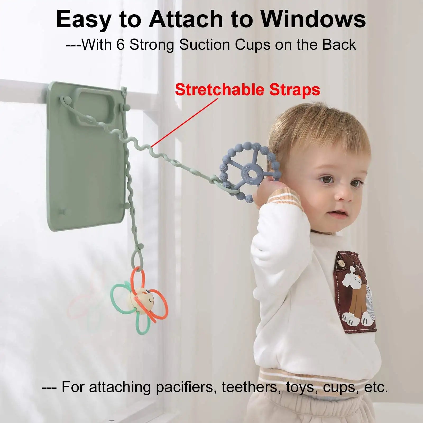 Suction mat stuck to a window with toys hanging from straps