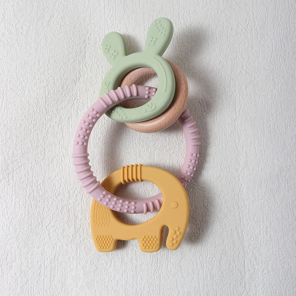 Three colorful silicone teething rings on a light gray background