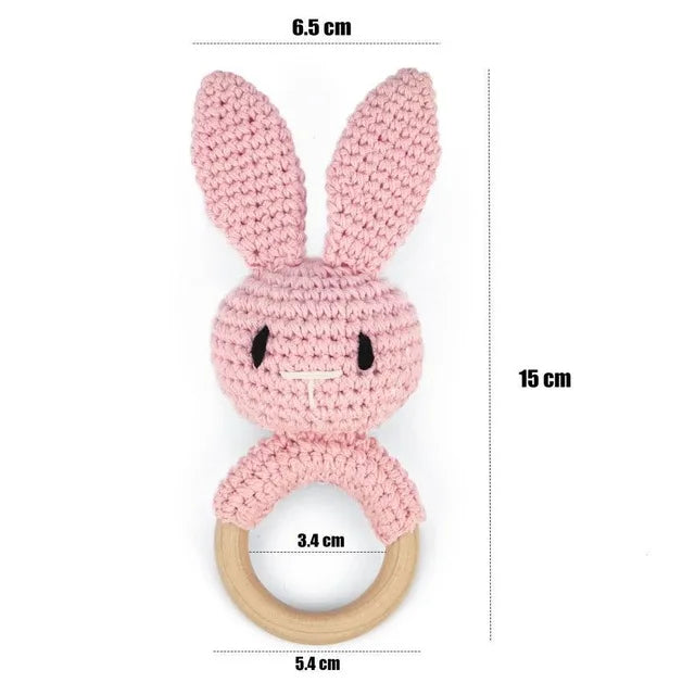 Pink knitted bunny teething ring with measurements on a white background