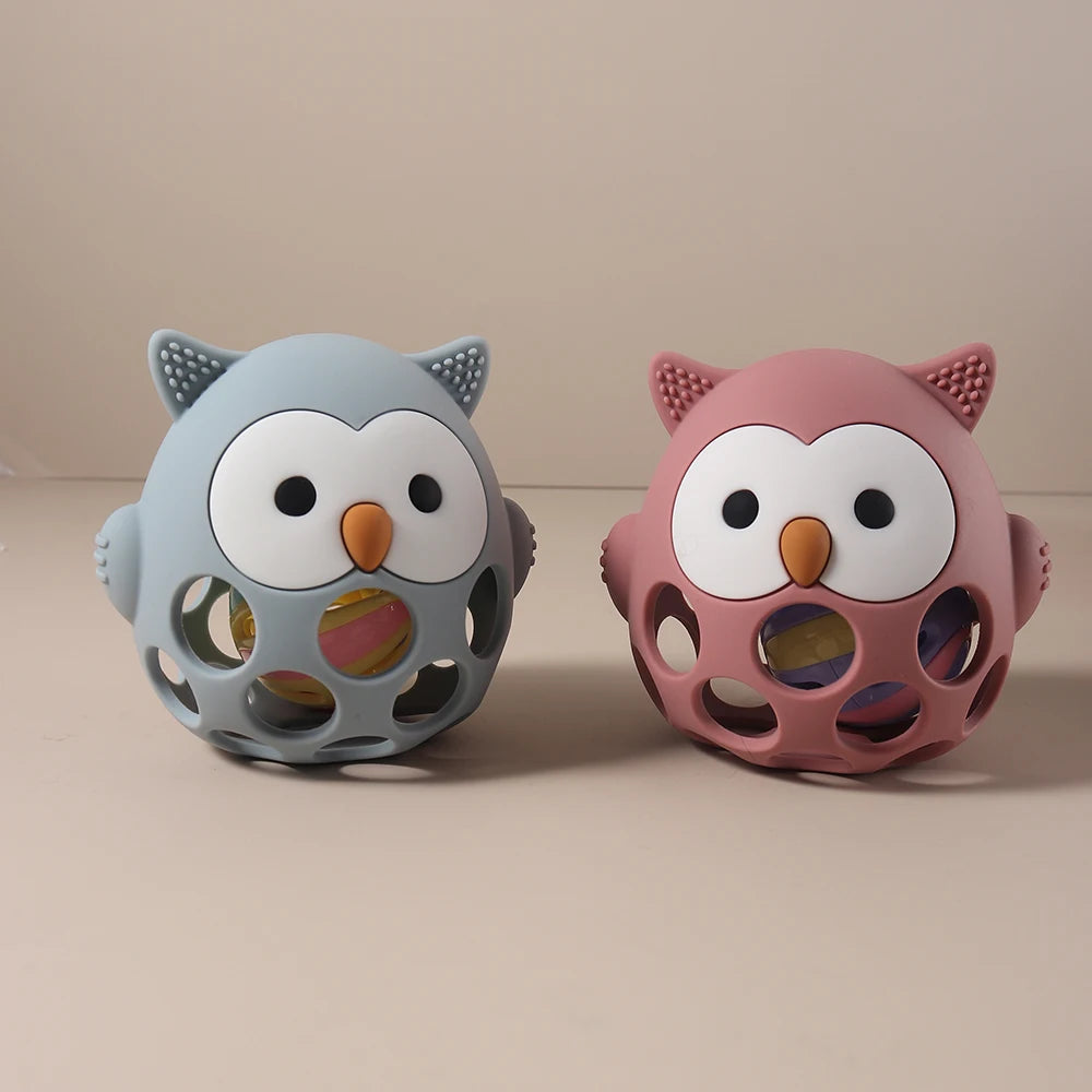 Two owl-shaped toys, one blue and one pink, on a beige background.
