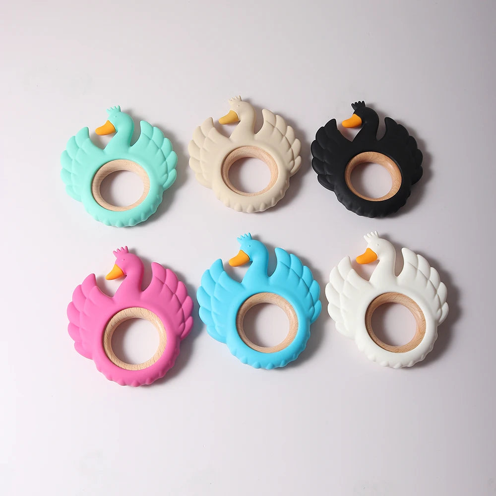 Set of six colorful swan-shaped teething rings on a light gray background