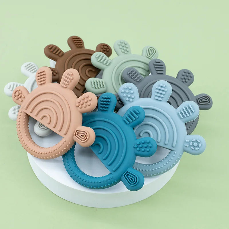 Pile of rainbow sun silicone teethers in many colors
