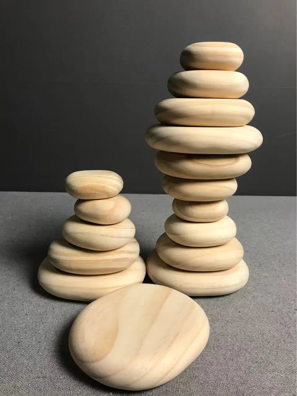 Stacks of wooden stones on a gray surface with a dark background