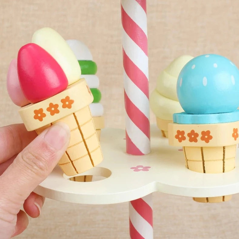 Hand holding Strawberry Three-Layer Ice Cream Tree, a wooden toy for stacking pretend play ice cream scoops, promoting creativity and independent play.