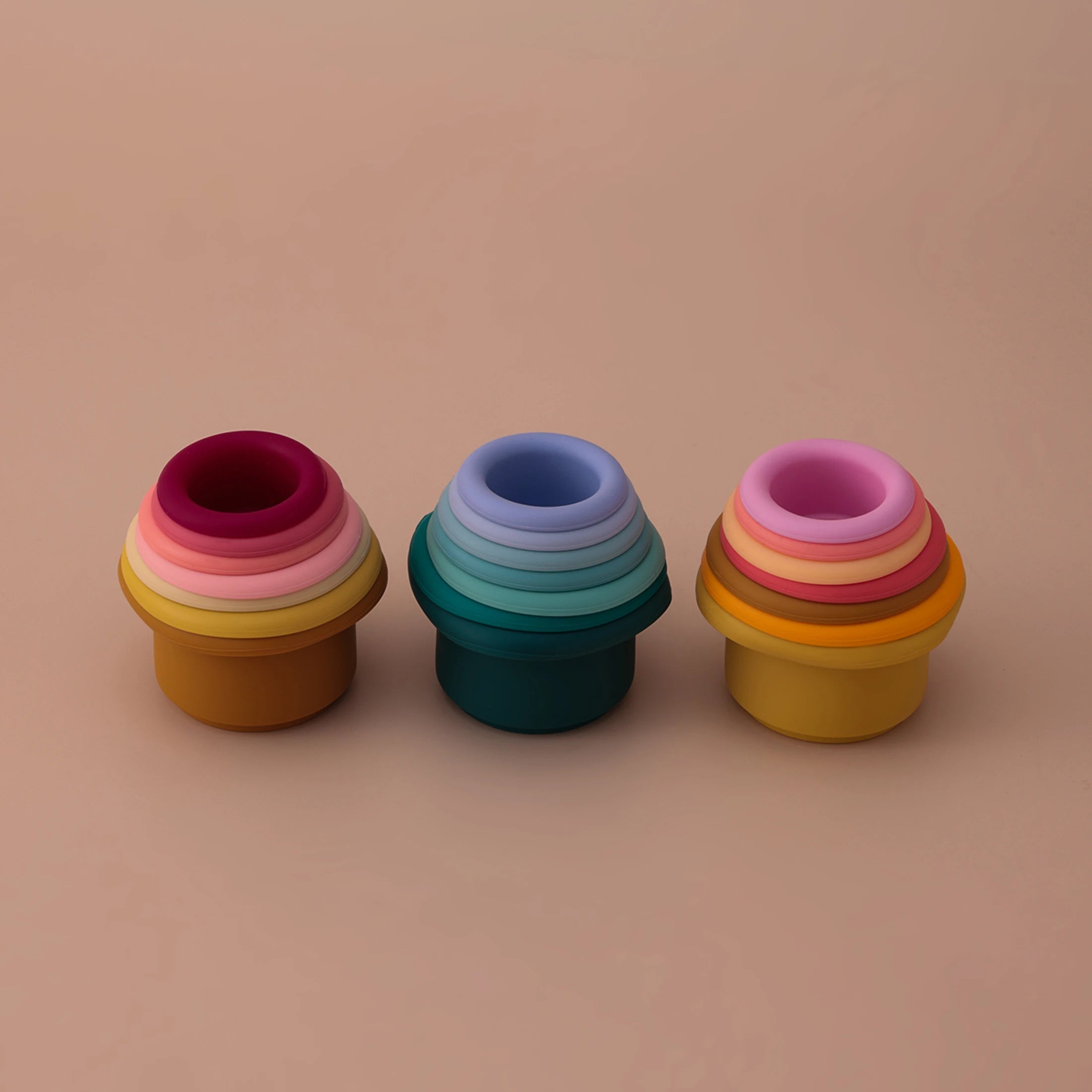 Three silicone hourglass stacking cup towers in different colors