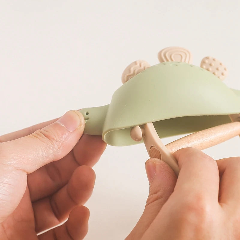 Person holding a green and pink hair clip against a light background