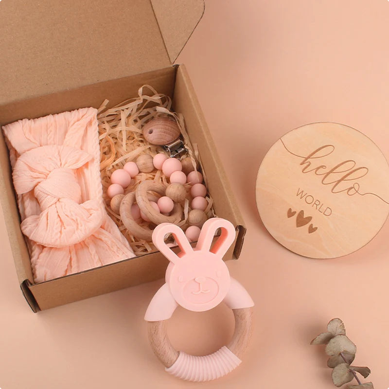 Baby Silicone Teether Newborn Gift Set featuring a pacifier chain, rabbit teether, round teether, baby hairband, and wooden card in a decorative box.