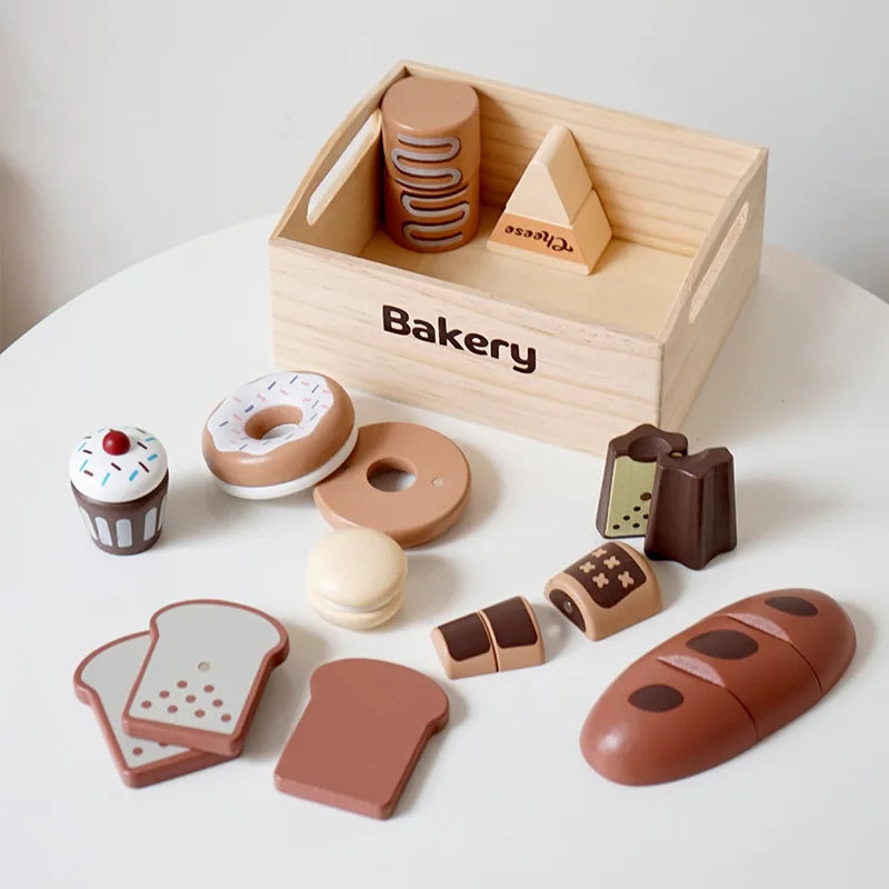 Wooden toy bakery set with various bread and pastry shapes on a white surface.