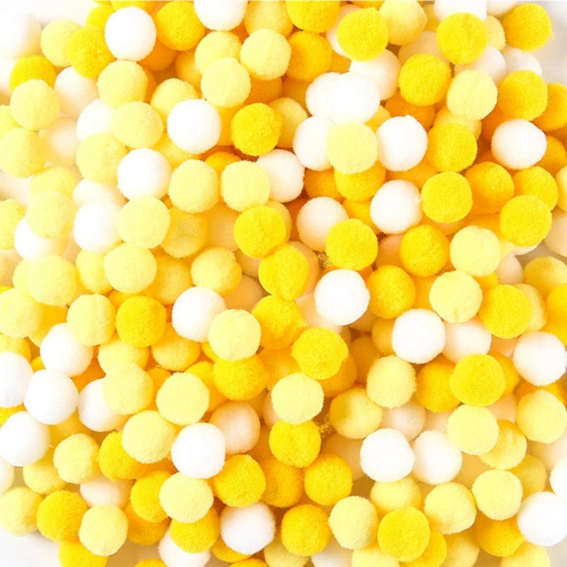 Close-up of yellow and white pom-poms on a white background
