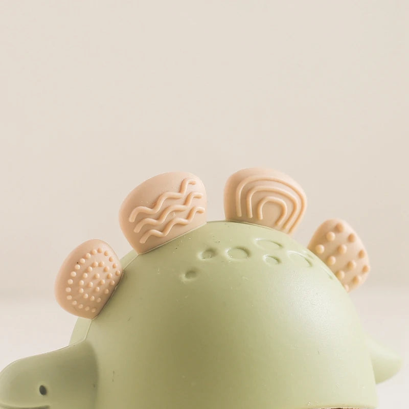 Green dinosaur-shaped toy with beige accents on a light background
