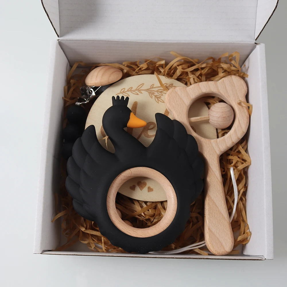 Black swan teething toy with wooden accessories in a white gift box