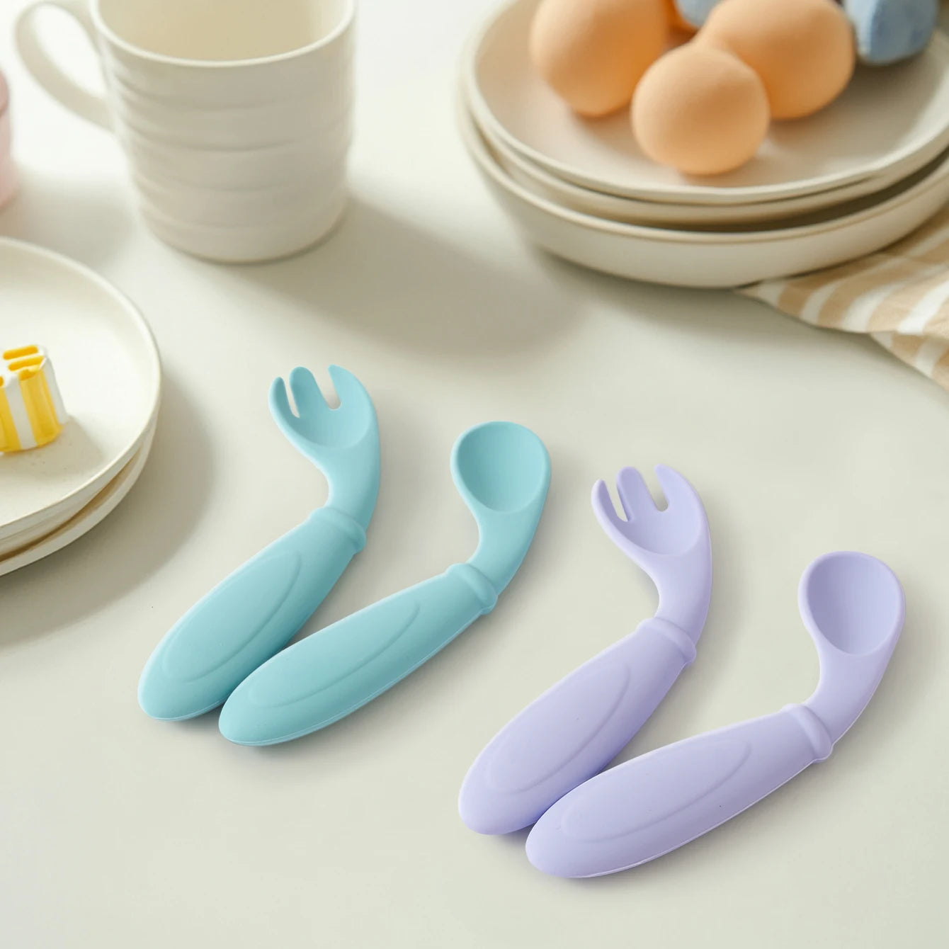 Aqua and lavender curved spoon and fork sets on a breakfast table