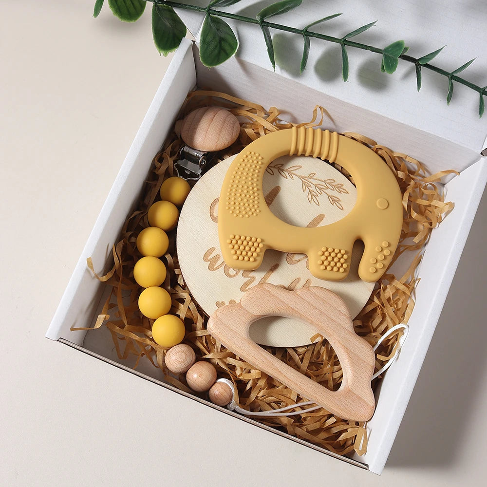 Teething toys in a gift box with yellow and wooden elements.