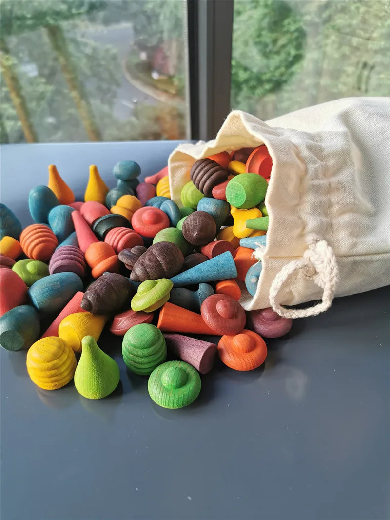 Colorful wood spilling out of a white drawstring bag on a reflective surface with a window view in the background.